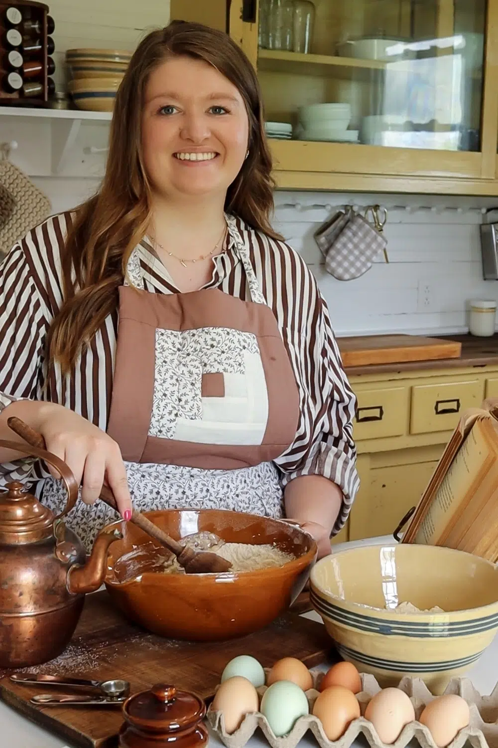 Sarah in her farmhouse kitchen mixing batter in a crock bowl.